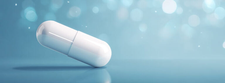 Nahaufnahme einer weißen Medikamentenkapsel vor unscharfem, blauem Hintergrund